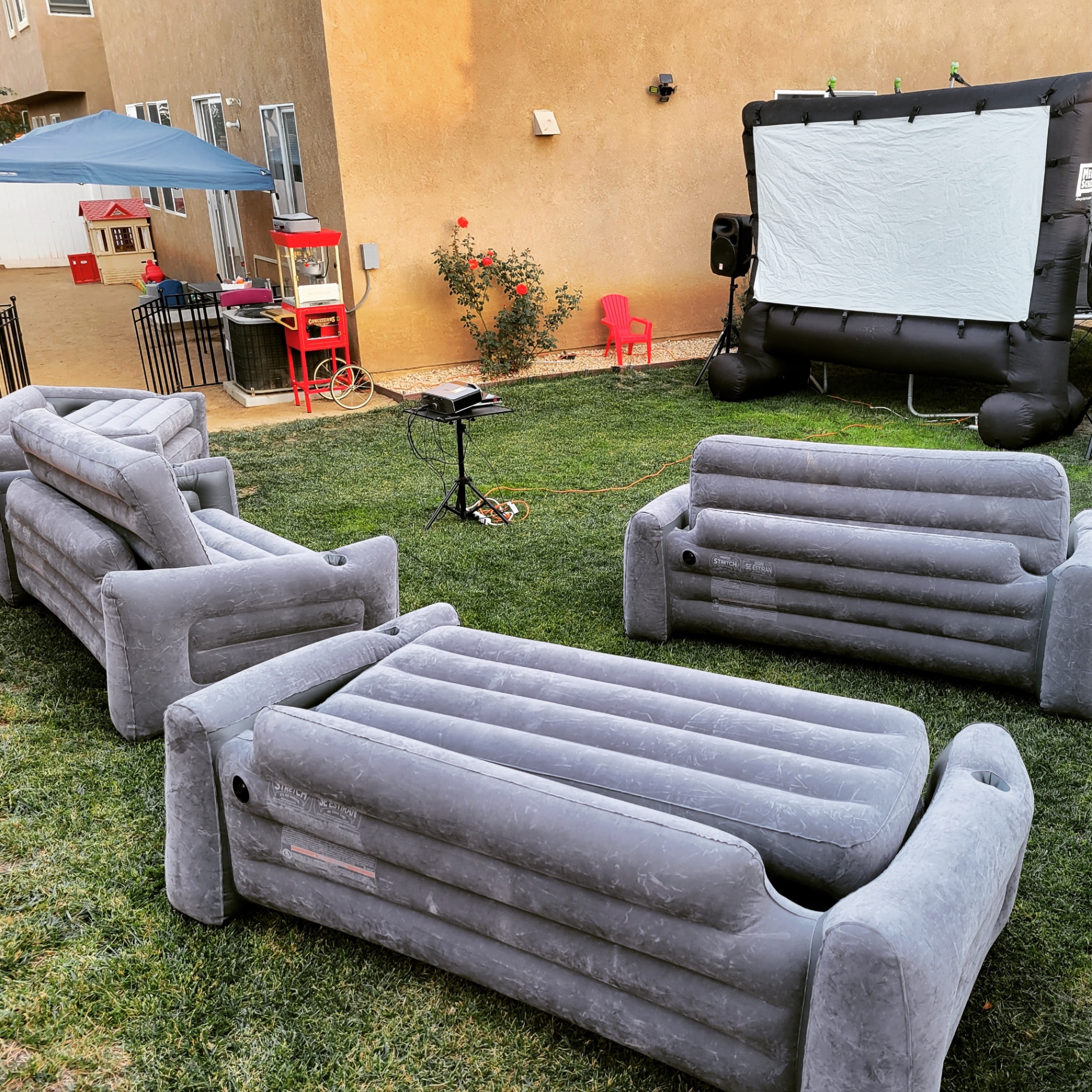 Inflatable lounge seating with outdoor movie screen setup for backyard party