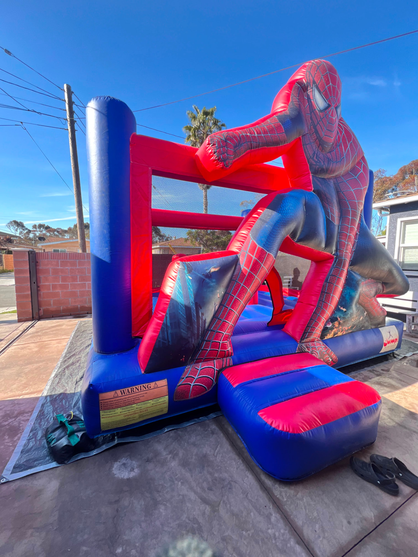Kids enjoying the Spider Man bounce house at a backyard party